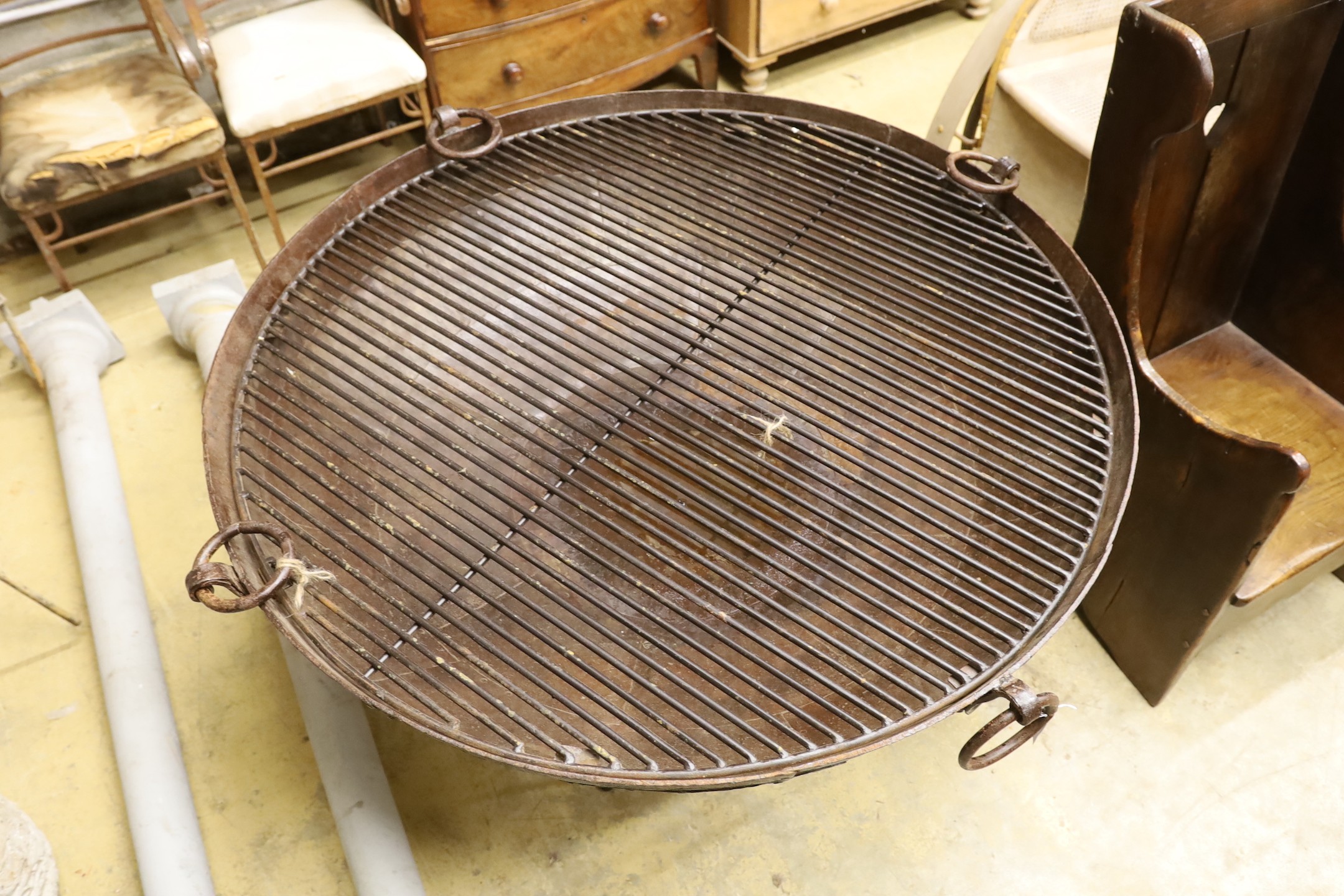A large riveted fire pit on stand with grill, diameter 133cm height 83cm